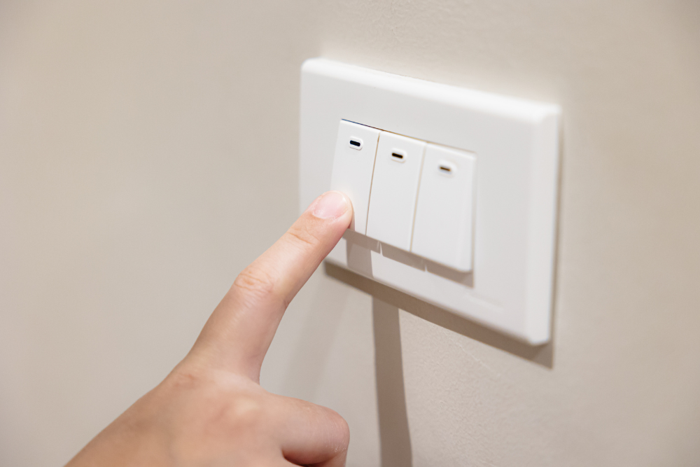 People press light switch to turn off the light for saving home energy