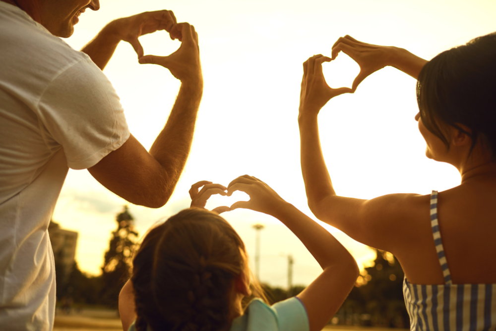 Family concept of happiness, Hands of Family Group People in the shape of a heart against the sunset